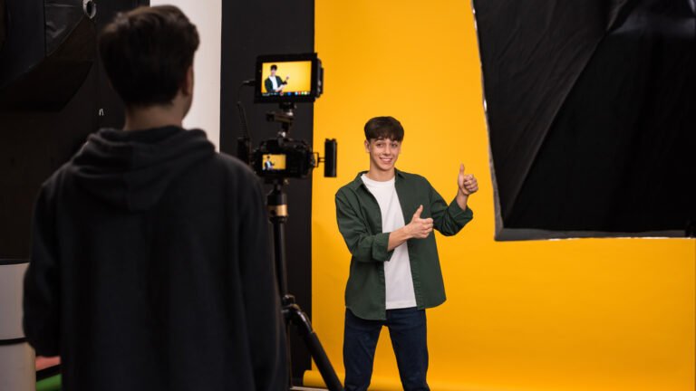 View of a professional photographer shooting a young woman using a camera with external display, yellow background